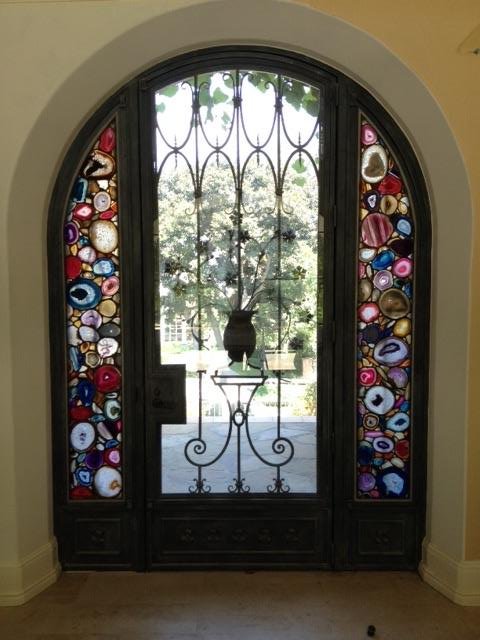 Custom entry door surround with inset colorful agate glass slices and ironwork