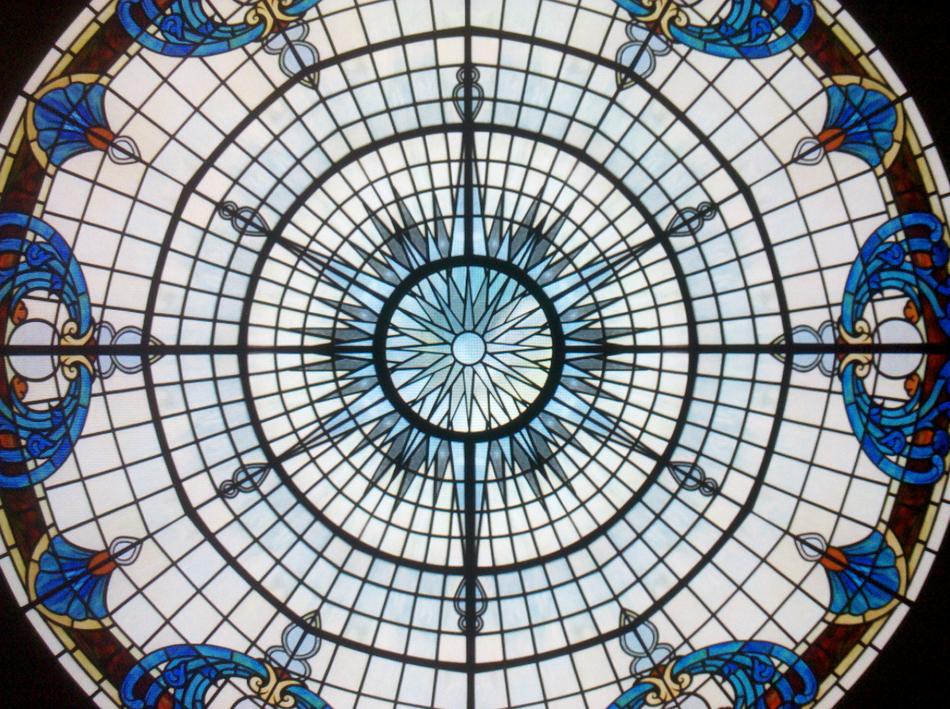 Large custom stained glass dome skylight with Art Nouveau floral medallions and radial star pattern