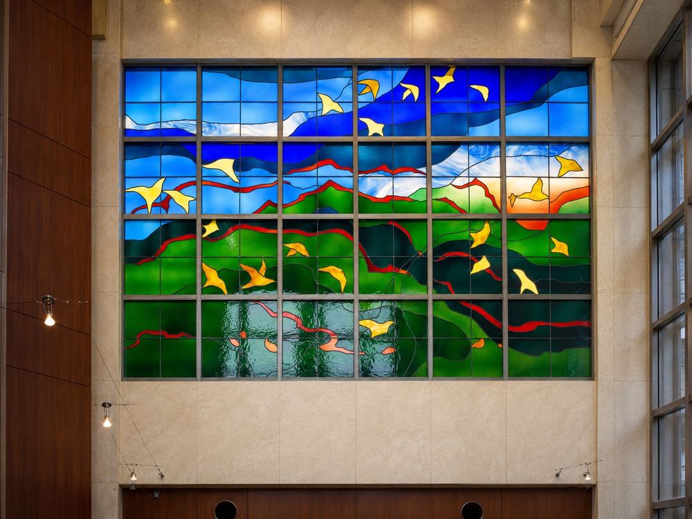 Large architectural stained glass wall installation depicting birds in flight over a landscape, Ginza, Japan