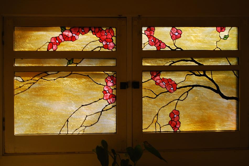 Custom stained glass cabinet doors with cherry blossom branch design in warm gold tones