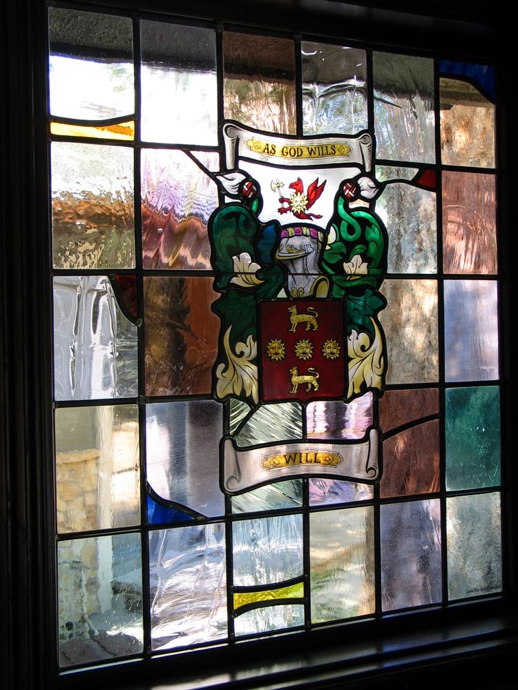 Painted stained glass window with a hand-painted family coat of arms and heraldic motto, custom armorial glass