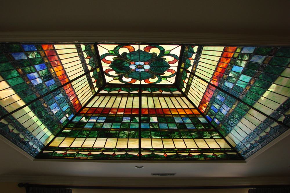 Custom stained glass skylight ceiling with floral medallion and geometric border design